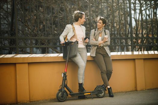 A two successful businesswomen chatting while have a coffee break in the city.