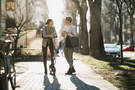 A two successful businesswomen chatting while walking through the city.