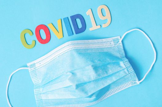 Disposable face mask with letters and text corona virus, top view, health concept