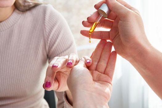Moisturizing oil for cuticles. The woman cares for hands and nails.