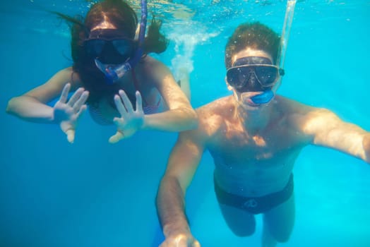 Under water love. a young couple snorkeling in turquoise water