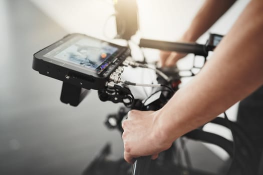 Holding steady to get great shots. Behind the scenes over the shoulder shot of an unrecognizable person operating a state of the art video camera inside of a studio