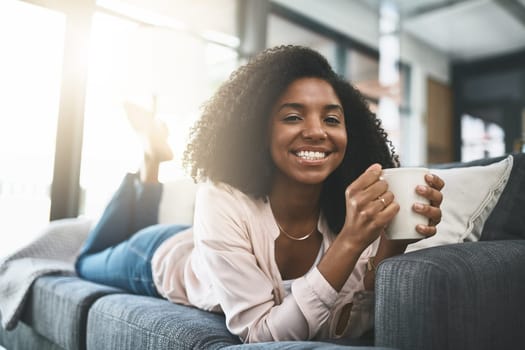 Coffee keeps me smiling. an attractive young woman relaxing at home