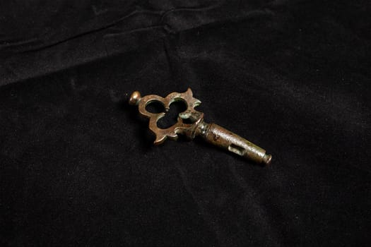 Gold key on a black background. Vintage copper lock key. High quality photo