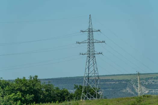 High voltage towers with sky background. Power line support with wires for electricity transmission. High voltage grid tower with wire cable at distribution station. Energy industry, energy saving.