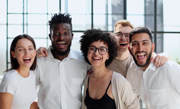 Portrait of successful creative business team looking at camera and smiling. Diverse business people standing together at startup.