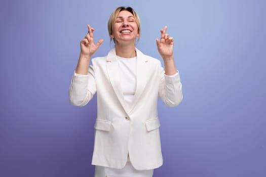 adorable kind young blond business leader woman dressed in a white jacket and skirt dreamily looks up.