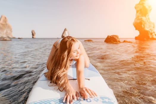 Close up shot of happy young caucasian woman looking at camera and smiling. Cute woman portrait in bikini posing on a volcanic rock high above the sea