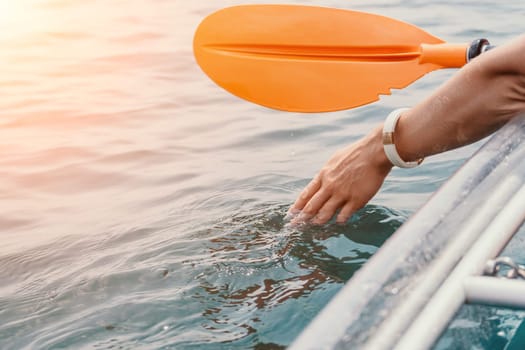 Woman in kayak back view. Happy young woman with long hair floating in transparent kayak on the crystal clear sea. Summer holiday vacation and cheerful female people having fun on the boat.