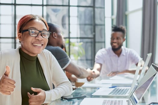 Portrait Of Businesswoman In Modern Open Plan Office With Business Team Working In Backgroun