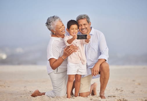 Selfie, travel and grandparents with child at beach for vacation, bonding and generations. Picture, happy and young boy with senior man and woman in nature for smile, happiness and technology.