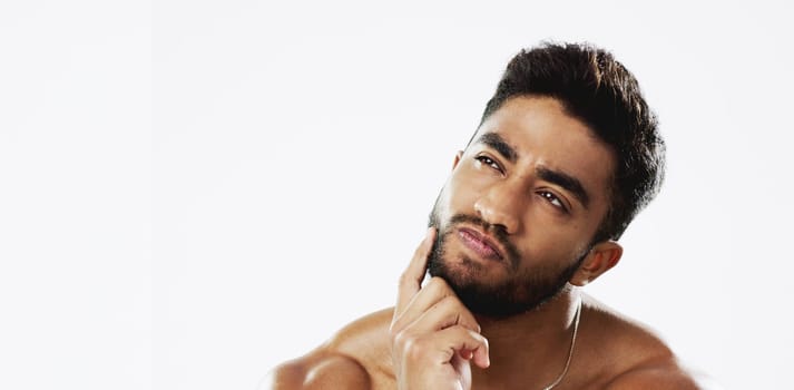 Confused, thinking and face of man in studio for wellness, skincare and hygiene on white background. Doubt, portrait and indian male model with unsure emoji contemplating beauty cosmetic or body care.