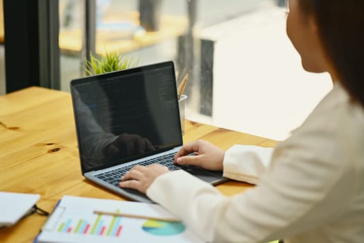 Side view of female developer working with coded data on computer screen at her office.