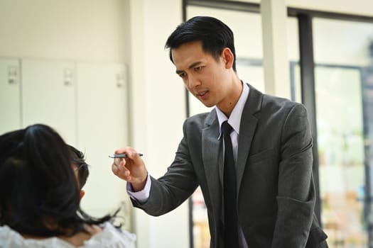 Furious male boss scolding employee with bad work results at group meeting. Emotional pressure, stress at work.