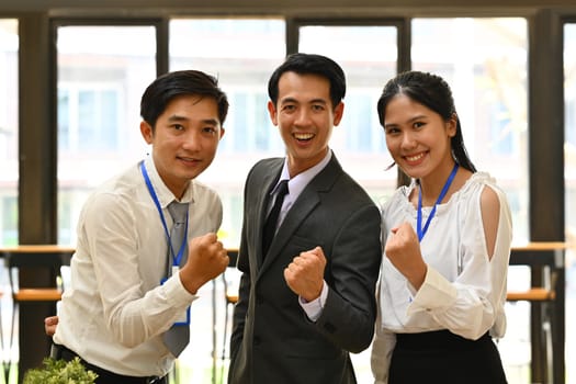 Team of excited employees making yes gesture, celebrating corporate achievement. Business, teamwork, success and winning concept.