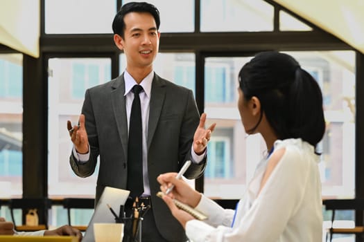 Confident businessman explaining project details, talking about company strategy and business plan during meeting.