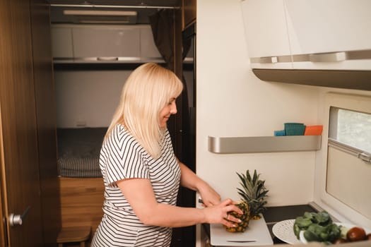 a woman cooking food in the kitchen inside a motorhome, the interior of a motorhome.