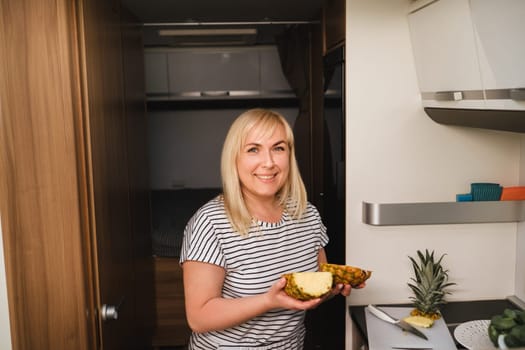 a woman cooking food in the kitchen inside a motorhome, the interior of a motorhome.