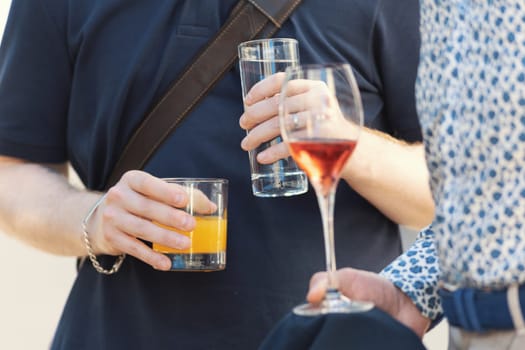 Two person drinking alcoholic drinks at the outdoors party. Mid shot