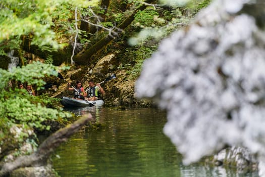 A young couple enjoying an idyllic kayak ride in the middle of a beautiful river surrounded by forest greenery.