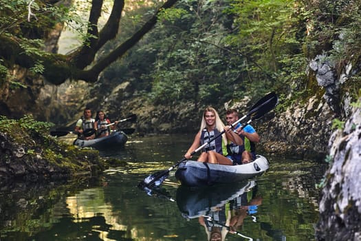 A group of friends enjoying having fun and kayaking while exploring the calm river, surrounding forest and large natural river canyons.