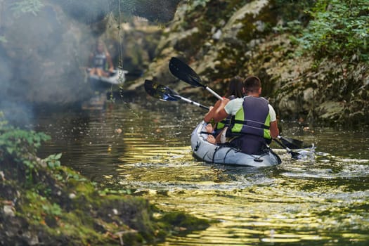 A group of friends enjoying having fun and kayaking while exploring the calm river, surrounding forest and large natural river canyons.