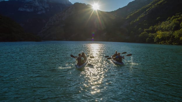 A group of friends enjoying fun and kayaking exploring the calm river, surrounding forest and large natural river canyons during an idyllic sunset