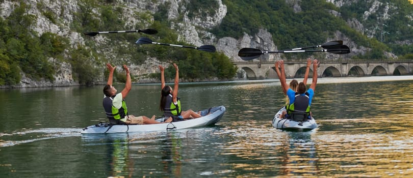 A group of friends enjoying having fun and kayaking while exploring the calm river, surrounding forest and large natural river canyons.