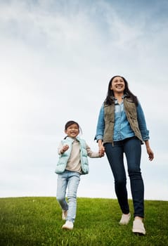 Its all smiles when were outside. a woman holding her little girls hand as they walk outdoors