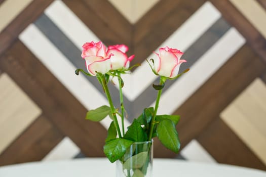 pink roses in a transparent vase on a tablecloth