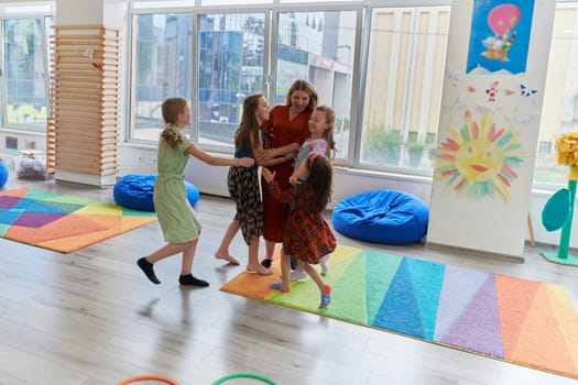 A child hugging a teacher in a modern kindergarten. High quality photo