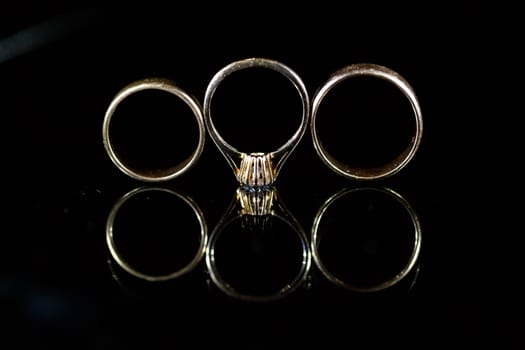 Gold wedding ring on black glass