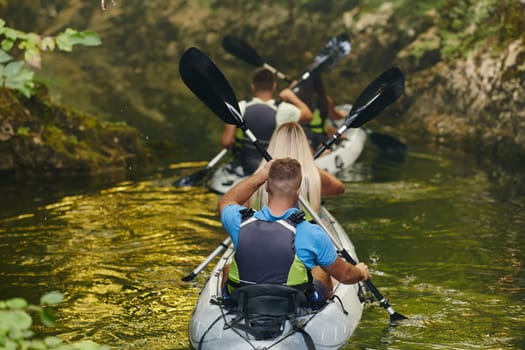 A group of friends enjoying having fun and kayaking while exploring the calm river, surrounding forest and large natural river canyons.