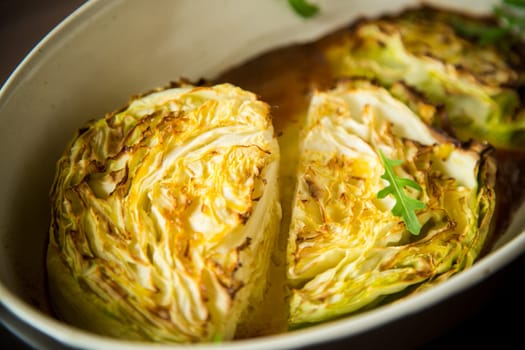 Young early cabbage baked in pieces in the oven, in a ceramic form.
