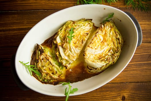 Young early cabbage baked in pieces in the oven, in a ceramic form.