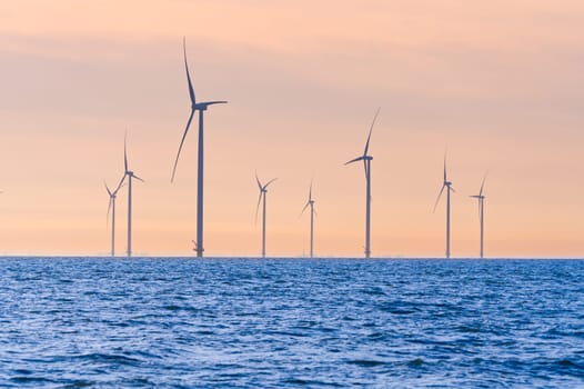 Offshore Windmill farm. windmills isolated at sea on a beautiful bright day Netherlands. green energy Flevoland global warming renewable enrgy with windmills