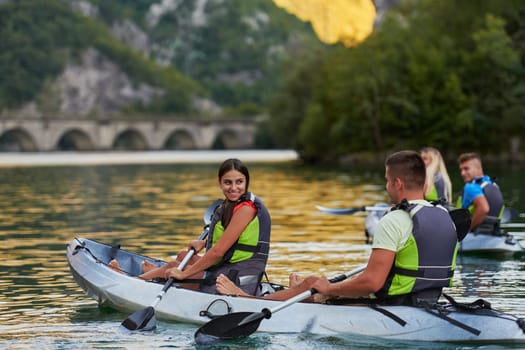 A group of friends enjoying having fun and kayaking while exploring the calm river, surrounding forest and large natural river canyons.