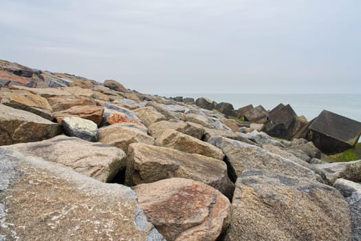 Massive concrete breakwaters on Sea coast. protect the coast from destructive effects of sea waves. heaps of stones on the shore. Stone against the waves. Shore protection.