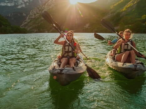 A group of friends enjoying fun and kayaking exploring the calm river, surrounding forest and large natural river canyons during an idyllic sunset