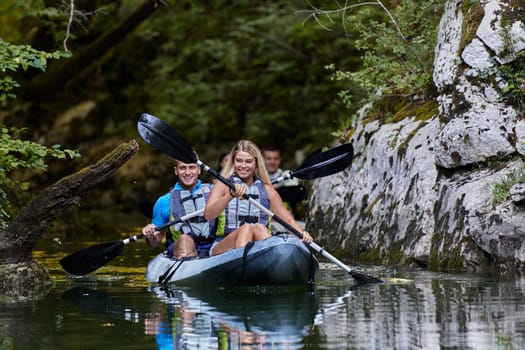 A group of friends enjoying having fun and kayaking while exploring the calm river, surrounding forest and large natural river canyons.