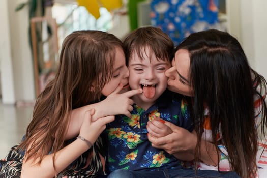 A girl and a woman hug a child with down syndrome in a modern preschool institution. High quality photo