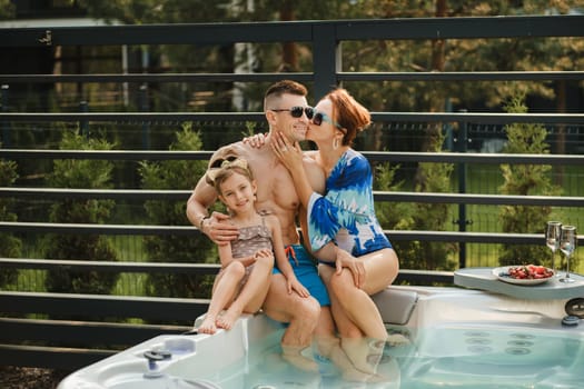 In summer, the family rests in the outdoor hot tub.