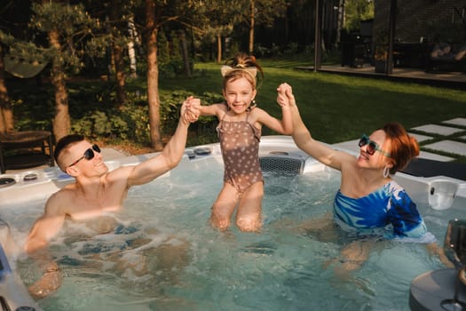 In summer, the family rests in the outdoor hot tub.