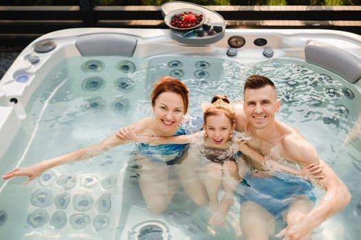 In summer, the family rests in the outdoor hot tub.