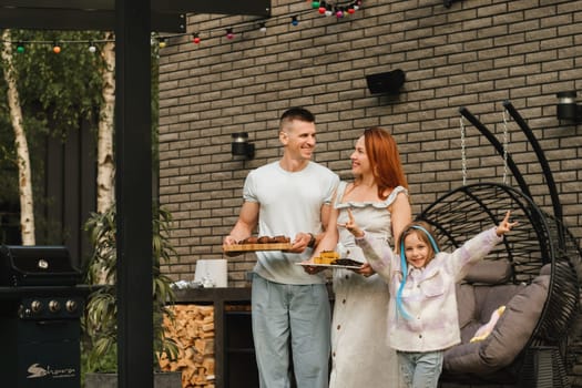 A happy family has prepared lunch and will eat at their house. Portrait of a family with food in their hands.