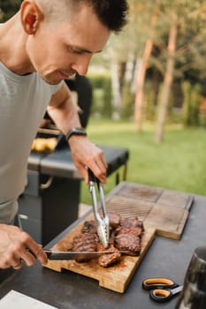 A man on the street cooked a steak on the grill in a barbecue.