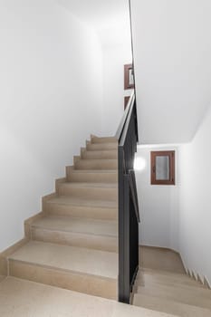 An empty indoor staircase with handrails and emergency ladder.