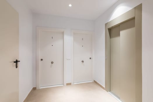 White and clean floor with Elevator and doors to apartments of a Modern Building.