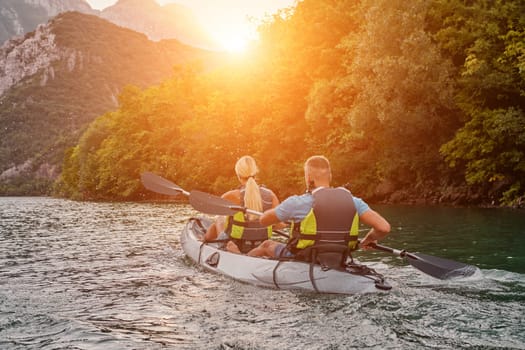 A group of friends enjoying fun and kayaking exploring the calm river, surrounding forest and large natural river canyons during an idyllic sunset