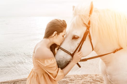 A woman in a dress stands next to a white horse on a beach, with the blue sky and sea in the background